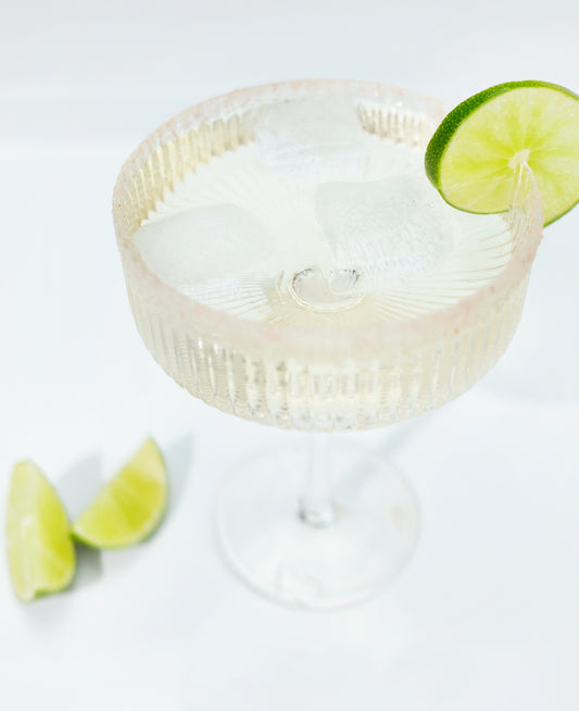 Margarita cocktail, salted rim, garnished with limes.